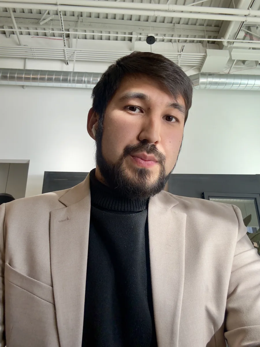 Oybek Abdualiev wearing a beige blazer and black turtleneck